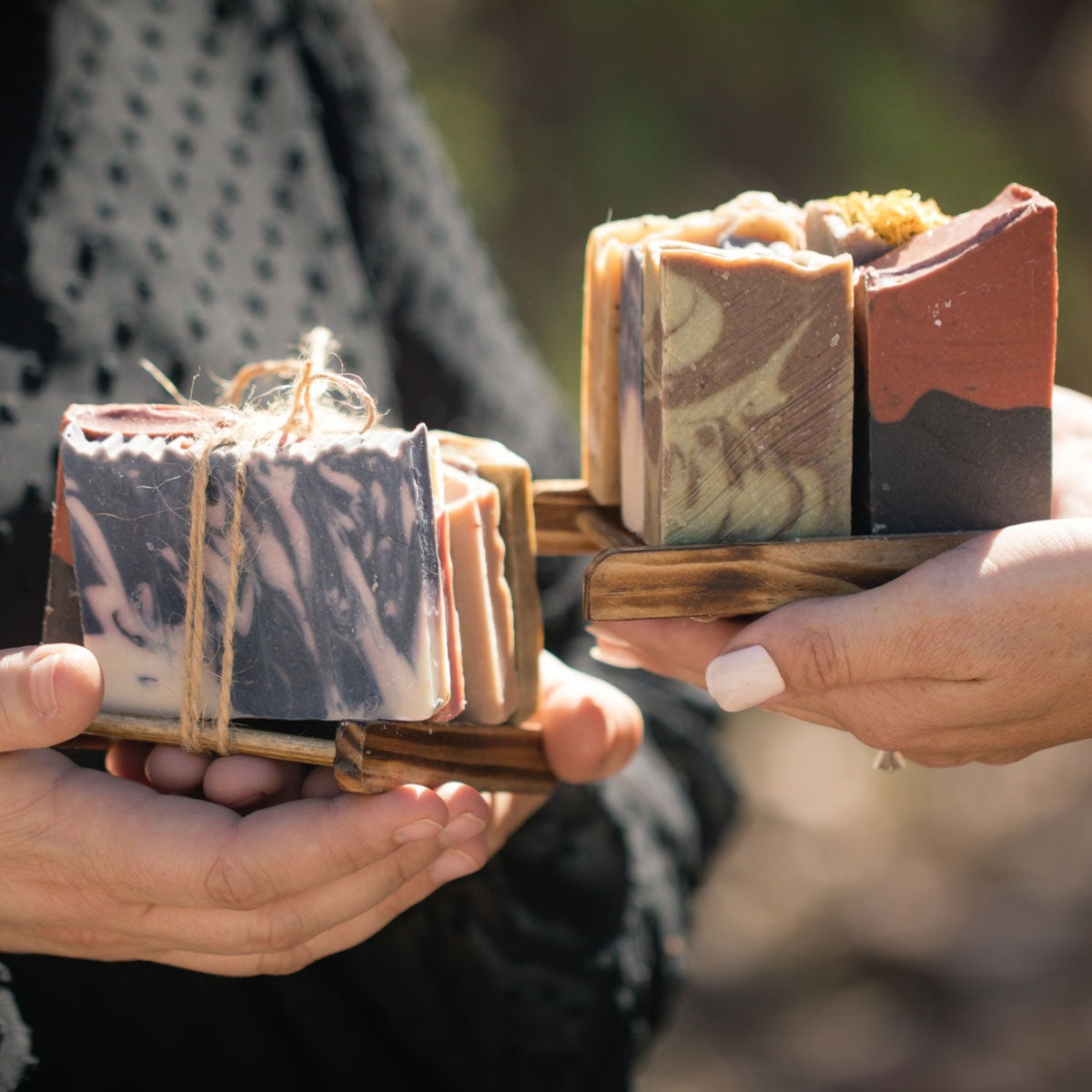 people holding handmade soap end trays 